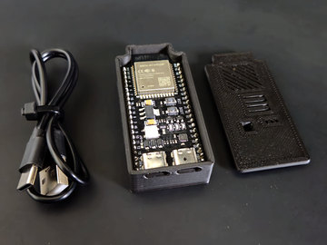 SimDrive: placa com ESP32-S3 dentro do gabinete impresso em 3D, ao lado da tampa e do cabo USB